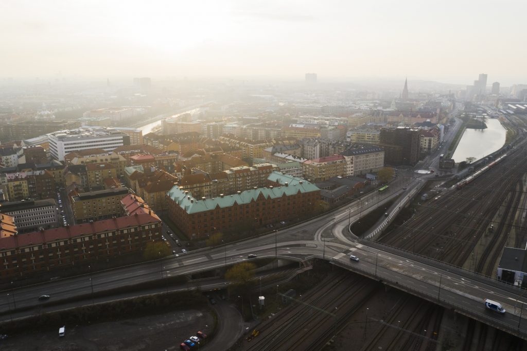 flygfoto över tågspår, bilväg och stadsbebyggelse